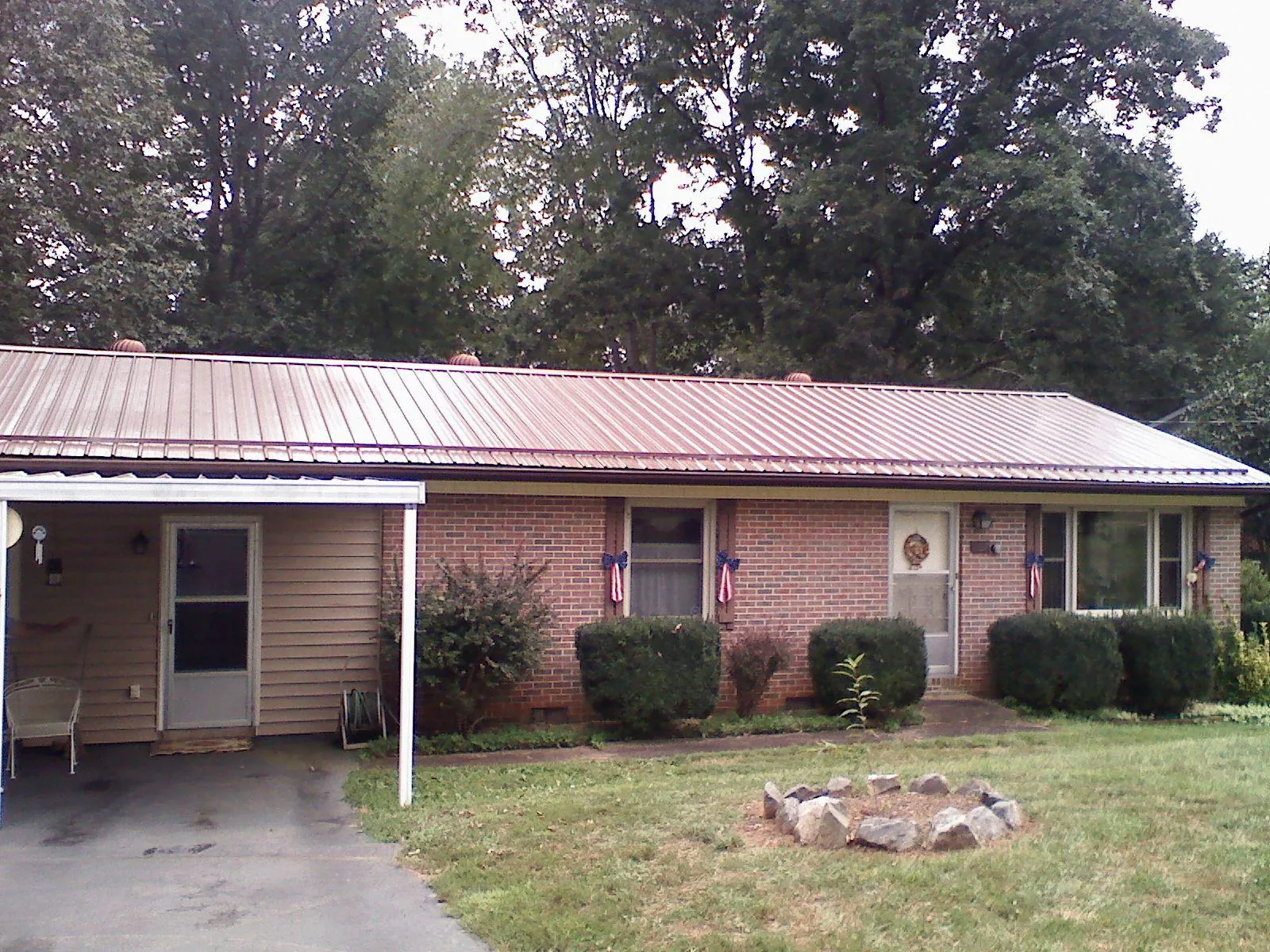 Bronze metal roof and carport on a brick ranch home — Roof Repair work by our crew in Bent Mountain